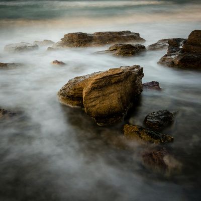 Peaceful natural scenery with calm water and mist.